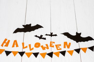 Cadılar Bayramı ve dekorasyon konsepti - beyaz arka planda uçan kartondan yapılmış siyah kağıt yarasalar ve kağıt kartlar