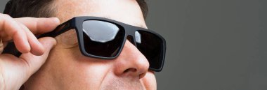 Gri arka planda gözlüklü bir adamın portresi.