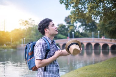Asya genç adam Yaş 25-30 yıl turist backpacker. O terli ve yorgun. park ve turistik merkezlere. sırasında belgili tanımlık tatil seyahat ve rahatla.