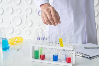 El bilim adamı yakından bilimsel araştırmada kullanılan kimyasalların koymak cam tüp tutamaçlarını kullanarak. Kimya Laboratuvarı.