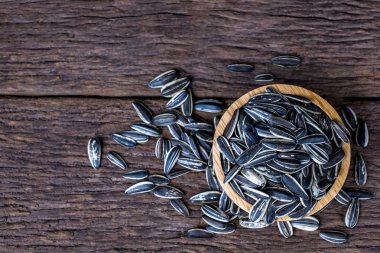 ayçiçeği tohumu grubu a ahşap Kupası en iyi görünüm ve kopya yer üstünde tahta arka plan ile. Bilim adı: Helianthus annuus.
