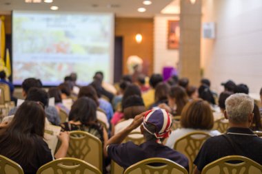 Arka plan bulanık. İş semineri için toplantı odasında birçok kişi oturuyor. Bir girişimci atölyesi..