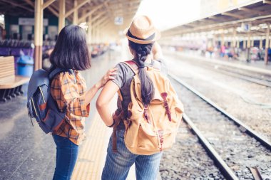 İki kişi Asyalı kadın turist ayakta taşıyan bir sırt çantası. Hua Lamphong Bangkok Tayland at trenin beklerdim. Yolculukları sırasında tatil.