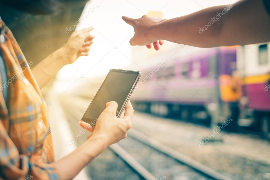 Close up hand. Travelers use smartphones to view maps and inquire about travel by pointing out places. at Hua Lamphong train station Bangkok Thailand.