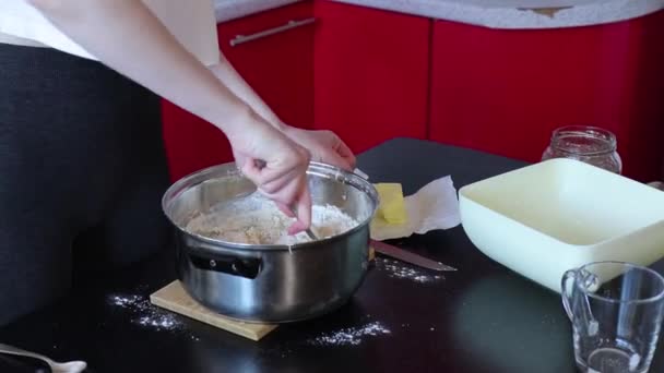 Жінка готує тісто для торта на сковороді на кухні — стокове відео