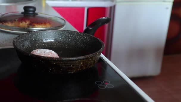 Mujer pone albóndigas crudas en una sartén caliente en la cocina — Vídeo de stock