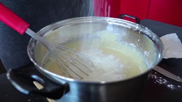 Kadın kek için hamur pişiriyor ve mutfaktaki tavaya un serpiyor. — Stok video