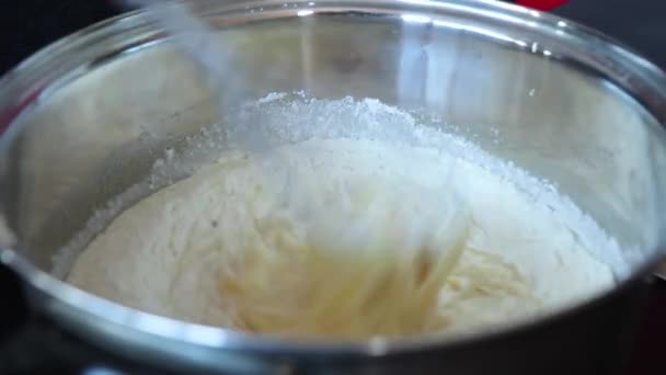 Femme cuisine la pâte pour gâteau dans une casserole dans la cuisine — Video