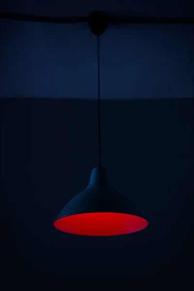 Photo of a pendant lamp with a red lamp