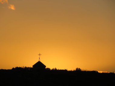 Güzel bir turuncu gökyüzü altındaki bir haç