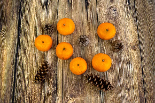 Mandalina ve koniler ahşap zemin üzerinde izole Yeni yıl ve Noel konsepti