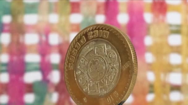 カラフルな背景に回転する10メキシコペソ硬貨 — ストック動画