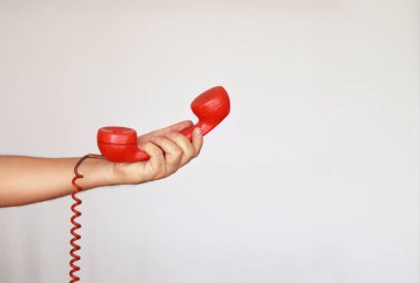 Beyaz arka plan üzerinde eski bir kırmızı telefon vermek 