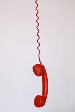 Beyaz arka planda asılı kırmızı vintage kablo telefon