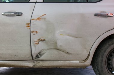 Hasarlı beyaz araba, kapıları çizikler