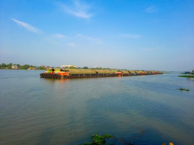 Gemi nehir boyunca kumlu bir mavnayı itiyor. görünüm.