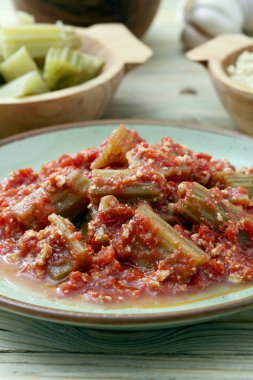 ahşap masa, çatal ile hizmet tabakta domates soslu enginar cardon yakın çekim
