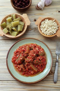 ahşap masa, üstten görünüm üzerinde çatal ile enginar cardon domates soslu tabakta servis