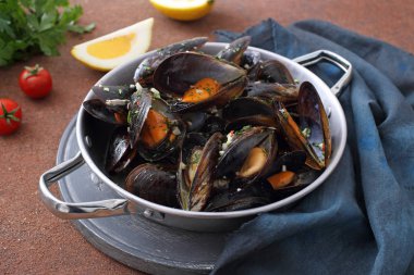 Kızarmış midye marinara adet kahverengi zemin üzerine metal tavada domates ile bölümü