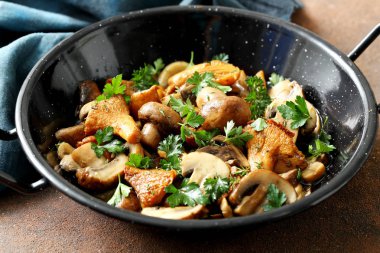 Metal tavada otlar ve baharatlarla pişirilmiş mantarların yakın plan görüntüsü