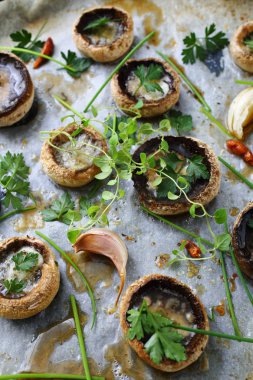 Metal tavada baharat ve bitkilerle pişirilmiş mantarlar.