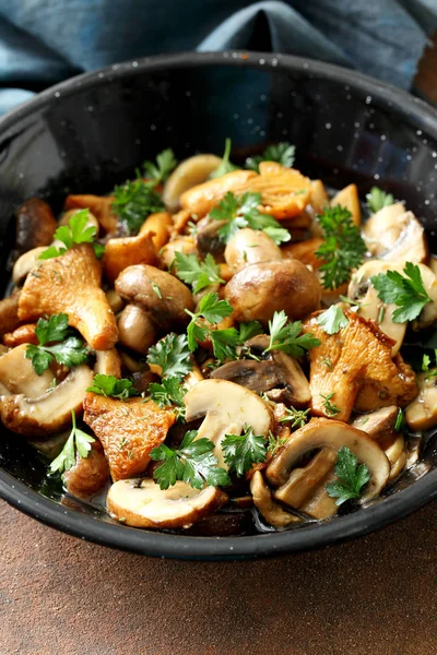 close-up view of cooked mushrooms with herbs and spices in metal pan