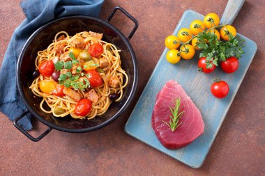 Ton balığı, domates ve zeytinli İtalyan spagettisi.