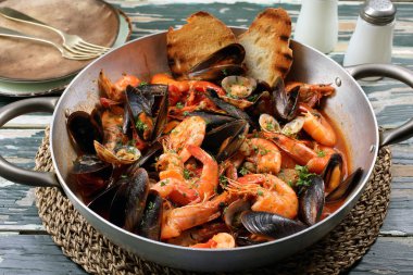Metal tavada domates soslu deniz ürünleri. 