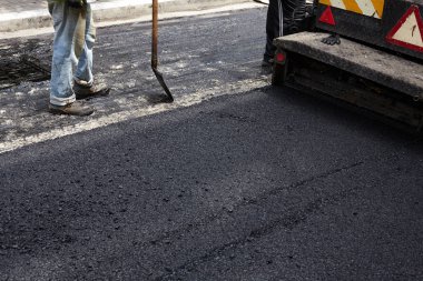 Asfalt Finişer aracını kullanarak yol yapımı sırasında işçi.