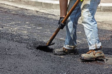 Asfalt Finişer aracını kullanarak yol yapımı sırasında işçi.