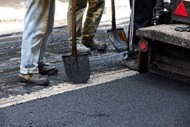 Asfalt Finişer araçlarını kullanarak yol yapımı sırasında işçilerin.