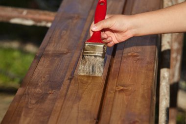 Dekoratör kahverengi boya ile ahşap boyama. İnşaat konsepti.