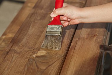 Dekoratör kahverengi boya ile ahşap boyama. İnşaat konsepti.