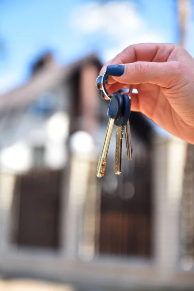 Keys in the hands on the background of the house