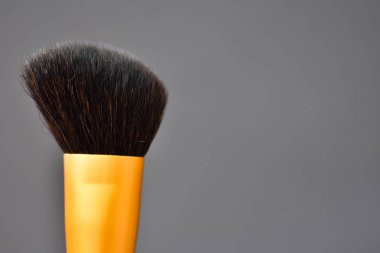 Gri arka plan üzerinde makyaj için güzel bir fırça. Yumuşak odaklama.