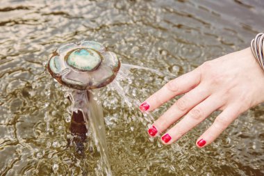 Kadın el ile Antik Çeşme detay