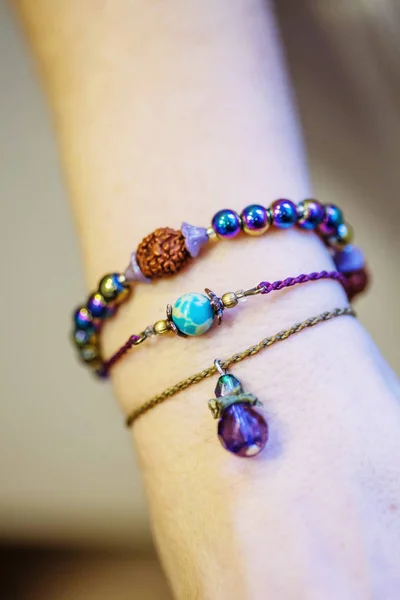 Three bracelets with natural stone beads on female hand