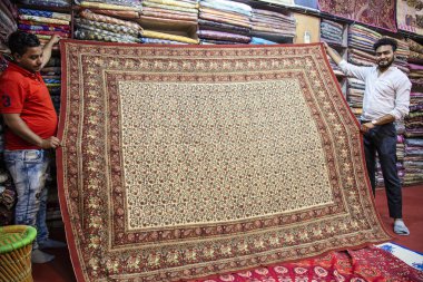 Jaipur, Rajasthan Hindistan, 20 Ocak 2019: tekstil fabrikası sahibi el yapımı gösterilen asistanı ile baskılı pamuk mandala yaprak