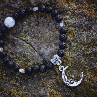 Kayalık zemin üzerine siyah lav taş ay kolye bilezik