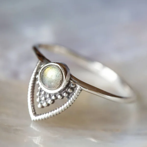Elegant female silver ring on natural shell nacrous background