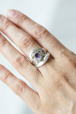 Ametist değerli taşlı gümüş yüzük takan kadın el