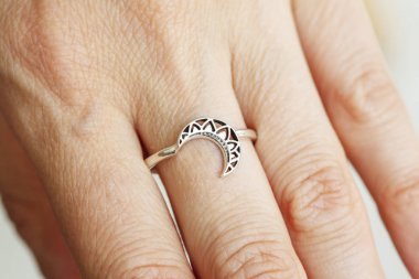 Ay şeklinde gümüş yüzük takan kadın el