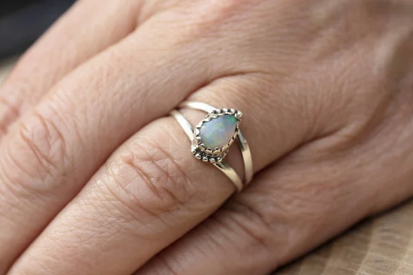 Silver ring with opal gemstone caboshon on female hand