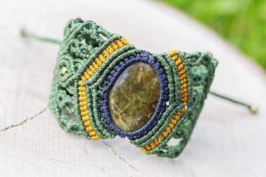 Doğal ahşap arka plan üzerinde doğal mineral değerli taş ile Macrame bilezik