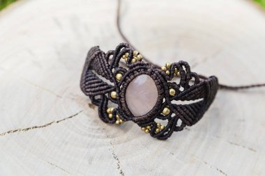Doğal ahşap arka plan üzerinde gül kuvars doğal mineral değerli taş ile Macrame bilezik