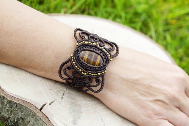 Doğal tyger göz mineral değerli taş ile macrame bilezik giyen kadın el