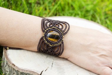 Doğal tyger göz mineral değerli taş ile macrame bilezik giyen kadın el