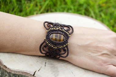Doğal tyger göz mineral değerli taş ile macrame bilezik giyen kadın el