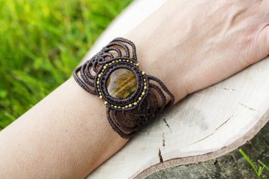 Doğal tyger göz mineral değerli taş ile macrame bilezik giyen kadın el