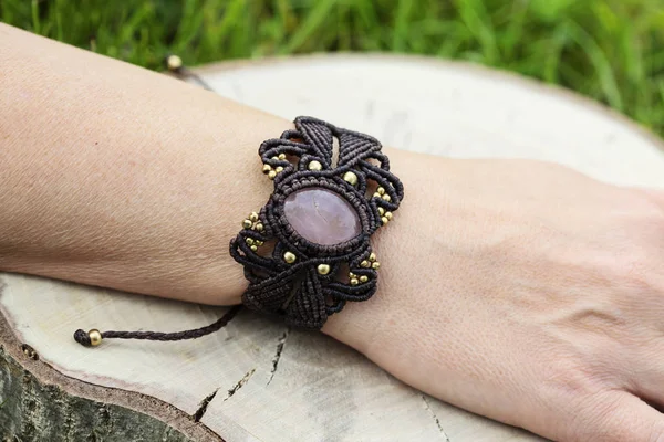 stock image Female hand wearing macrame bracelet with natural rose quartz mineral gemstone